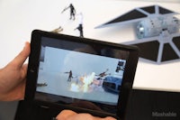 a person is holding an ipad with a star wars toy in front of it