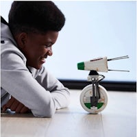 a young boy is playing with a star wars toy