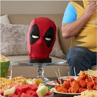 a deadpool mask sitting on a table with food on it